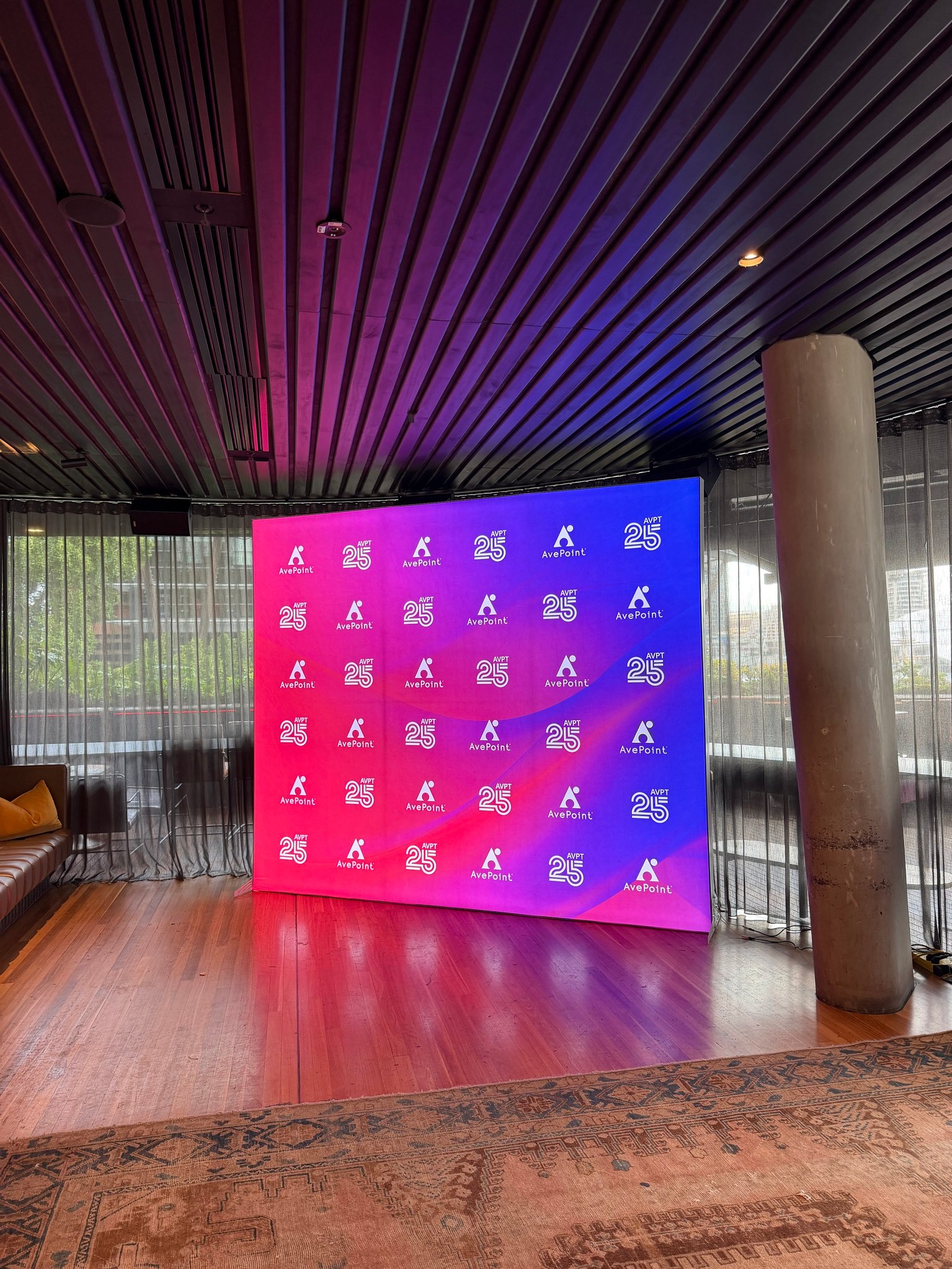 Illuminated AvePoint 25th anniversary media wall in pink and purple